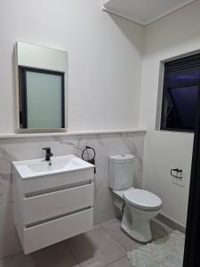 ein weißes Badezimmer mit Toilette und Waschbecken in der Unterkunft Munyaka Luxury Penthouse in Midrand