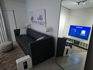 ein Wohnzimmer mit Sofa und Fernseher in der Unterkunft Munyaka Luxury Penthouse in Midrand + 10 Fotos