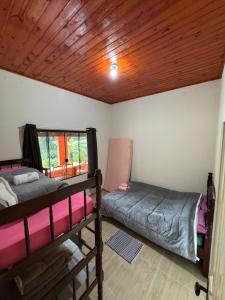 Habitación con 2 literas y techo de madera. en Hostel da Verinha, en Itamonte