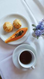 een bord met een wortel en een kopje koffie bij Hotel Real Ipiranga in Três Marias