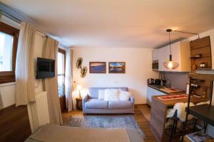 a living room with a couch and a kitchen at Monolocale in centro a Madesimo in Madesimo