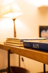 a desk with a laptop and books on it at Monolocale in centro a Madesimo in Madesimo