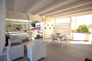 ein Zimmer mit Tisch und Stühlen auf einer Terrasse in der Unterkunft Luxury CASELLO 28 Affitti Brevi in Marconia