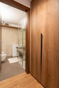a bathroom with a sliding glass door and a toilet at Monolocale in centro a Madesimo in Madesimo