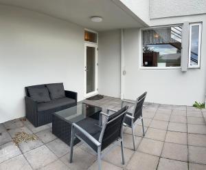 a patio with a table and chairs and a couch at Two rooms apartment in Reykjavik in Reykjavík