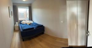a bedroom with a bed with blue sheets and a window at Two rooms apartment in Reykjavik in Reykjavík