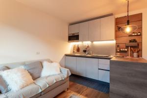 a living room with a couch and a kitchen at Monolocale in centro a Madesimo in Madesimo