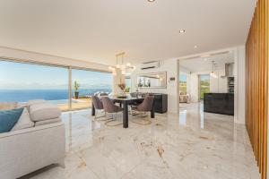 ein Wohnzimmer mit Tisch und ein Esszimmer in der Unterkunft Lê Maison Deluxe Madeira - Where Peace is breathed and Luxury is felt! in Ponta do Sol