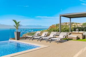 eine Gruppe von Stühlen neben einem Swimmingpool in der Unterkunft Lê Maison Deluxe Madeira - Where Peace is breathed and Luxury is felt! in Ponta do Sol