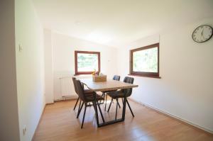 a dining room with a table and chairs and a clock at Grunthouse in Prebold