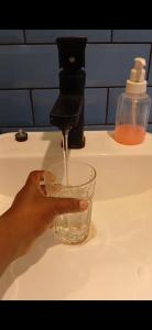 a person holding a cup under a water faucet at Tapioca Vila Boutique in Atins
