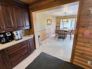 a kitchen with wooden cabinets and a dining room at L'toile Filante in Saint Zenon +3 photos