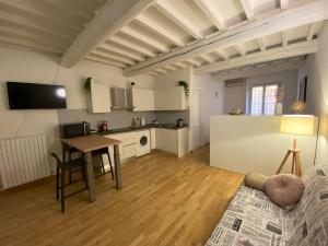 a living room with a table and a kitchen at Ganaceto54 in Modena