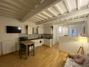 a living room with a table and a kitchen at Ganaceto54 in Modena