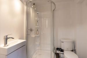 a bathroom with a shower and a toilet and a sink at Aurora Bayside Inn in Yellowknife