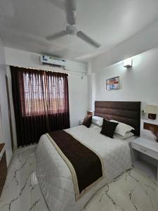 グルヴァイアールにあるKrishna Sannidhiのベッドルーム1室(大型ベッド1台、シーリングファン付)