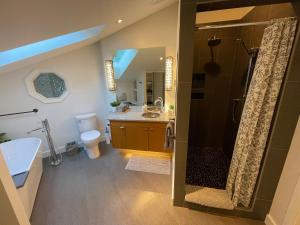 a bathroom with a shower and a sink and a toilet at Tyee Beach Oasis Bed and Breakfast in Nanoose Bay +41 photos