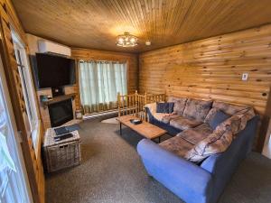 a living room with a large couch and a tv at L'toile Filante in Saint Zenon