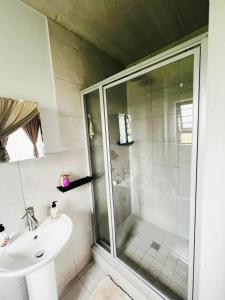 a bathroom with a shower and a sink at Felinga Guest House in Centurion +11 photos