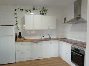 a white kitchen with white cabinets and a sink at Casa Playa Meira in Moaña