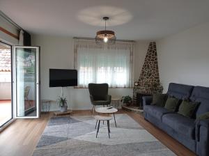 ein Wohnzimmer mit einem blauen Sofa und einem Fernseher in der Unterkunft Casa Playa Meira in Moaña