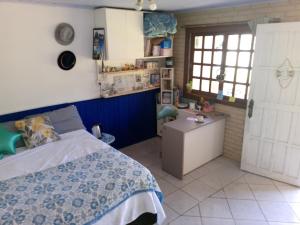 a bedroom with a bed and a desk and a kitchen at next to UNISC in Santa Cruz do Sul