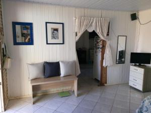 a living room with a bench and a television at next to UNISC in Santa Cruz do Sul
