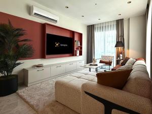 Una sala de estar con un sofá y un televisor de pantalla plana. en Qoople Excellence B55 designer duplex by the sea, en Alanya