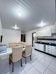 a kitchen and living room with a table and chairs at Apartamento Orquídea in Porto Belo