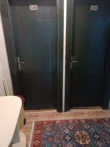 Un baño con dos puertas negras y una alfombra. en Suite Hotel, en Estambul