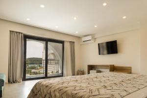 a bedroom with a large bed and a large window at Ostria Village in Syvota +50 photos