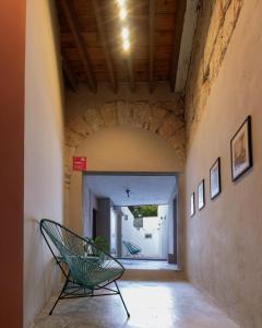 ein Flur mit einem grünen Stuhl in einem Gebäude in der Unterkunft Adhoc Barrio Antiguo in Monterrey + 50 Fotos