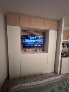 a living room with a tv on a wall at Clos d'AIX studio 11 in Aix-en-Provence