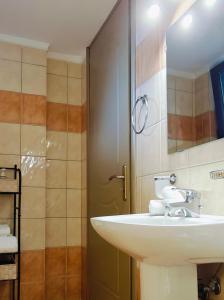 a bathroom with a white sink and a shower at Mountain View Apartments in Kalavrita