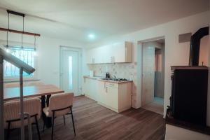 a kitchen with white cabinets and a table and chairs at SkyView Dežno in Makole +7 photos