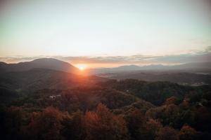 an image of the sun setting over the mountains at SkyView Dežno in Makole