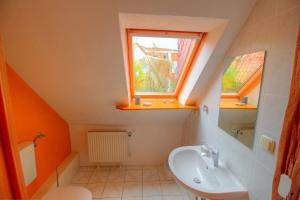 ein kleines Bad mit einem Waschbecken und einem Fenster in der Unterkunft Haus Störtebeker in Wismar