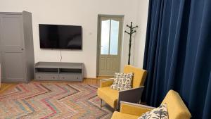 a living room with two chairs and a flat screen tv at Nostalgia in Turda