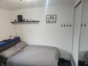 a bedroom with a bed and a shelf on the wall at Sandylands in Braystones