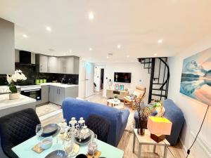 ein Wohnzimmer und eine Küche mit blauen Stühlen und einem Tisch in der Unterkunft Bright Modern Apartment in Northfield + 12 Fotos