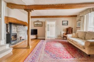a living room with a couch and a fireplace at Old Bell House - Spacious Period Home in the Heart of Somerton in Somerton