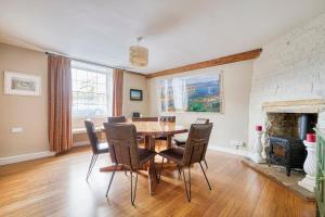 a dining room with a table and chairs and a fireplace at Old Bell House - Spacious Period Home in the Heart of Somerton in Somerton