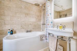 a bathroom with a white tub and a sink at Old Bell House - Spacious Period Home in the Heart of Somerton in Somerton +28 photos