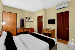 Un dormitorio con una cama blanca y un televisor. en Hotel O Blu View, en Aguada