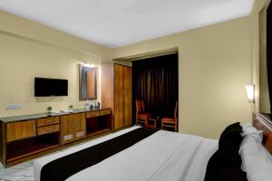 una habitación de hotel con una cama y un televisor en Hotel O Blu View, en Aguada