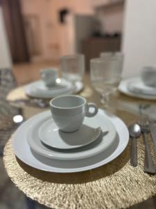 einen Tisch mit einer Kaffeetasse und Tellern darauf in der Unterkunft Regency Loft 02 in Petrolina