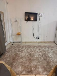 ein Wohnzimmer mit einem Teppich und einem TV an der Wand in der Unterkunft Regency Loft 02 in Petrolina