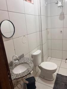 ein Badezimmer mit Toilette, Waschbecken und Spiegel in der Unterkunft Regency Loft 02 in Petrolina