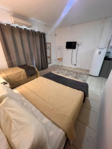 ein Zimmer mit zwei Betten und einem Fernseher an der Wand in der Unterkunft Regency Loft 02 in Petrolina