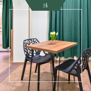 a table with two chairs and a vase with flowers on it at Hotel Serenity in Tbilisi City